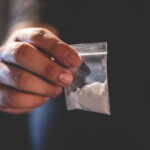 Hand holding bag of cocaine