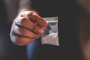 Hand holding bag of cocaine